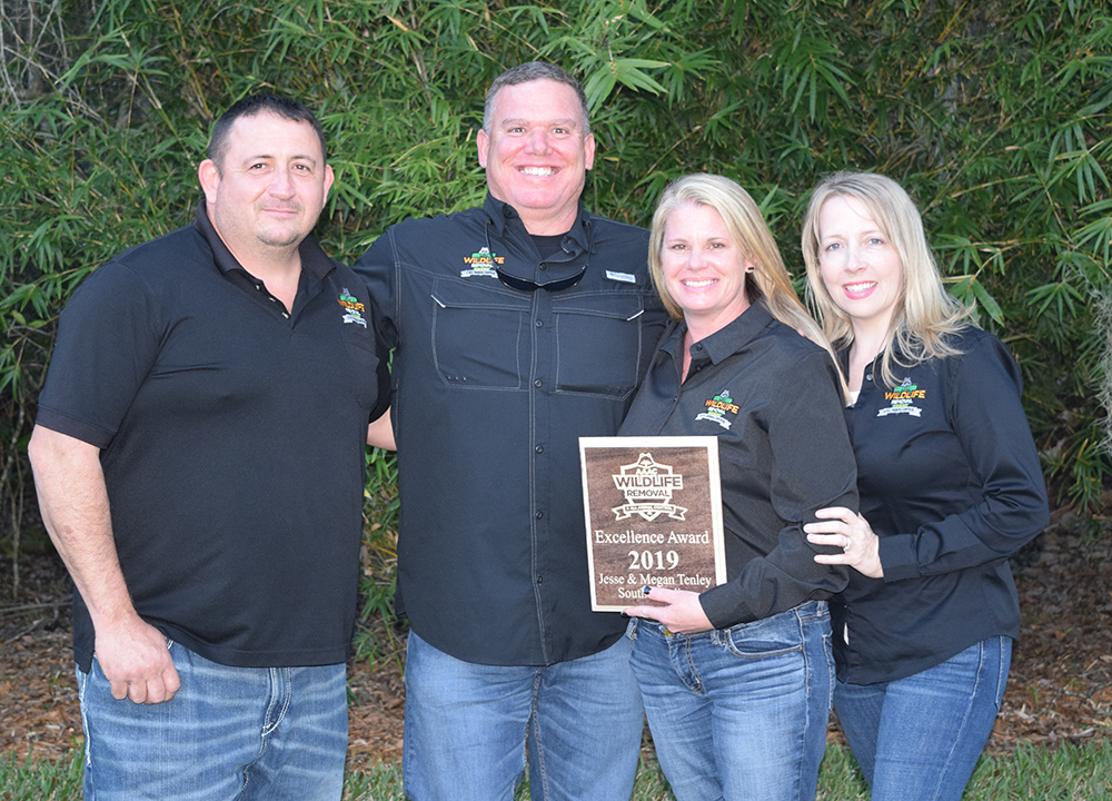 Wildlife Removal owners posing for a group photo holding a certificate of excellence award